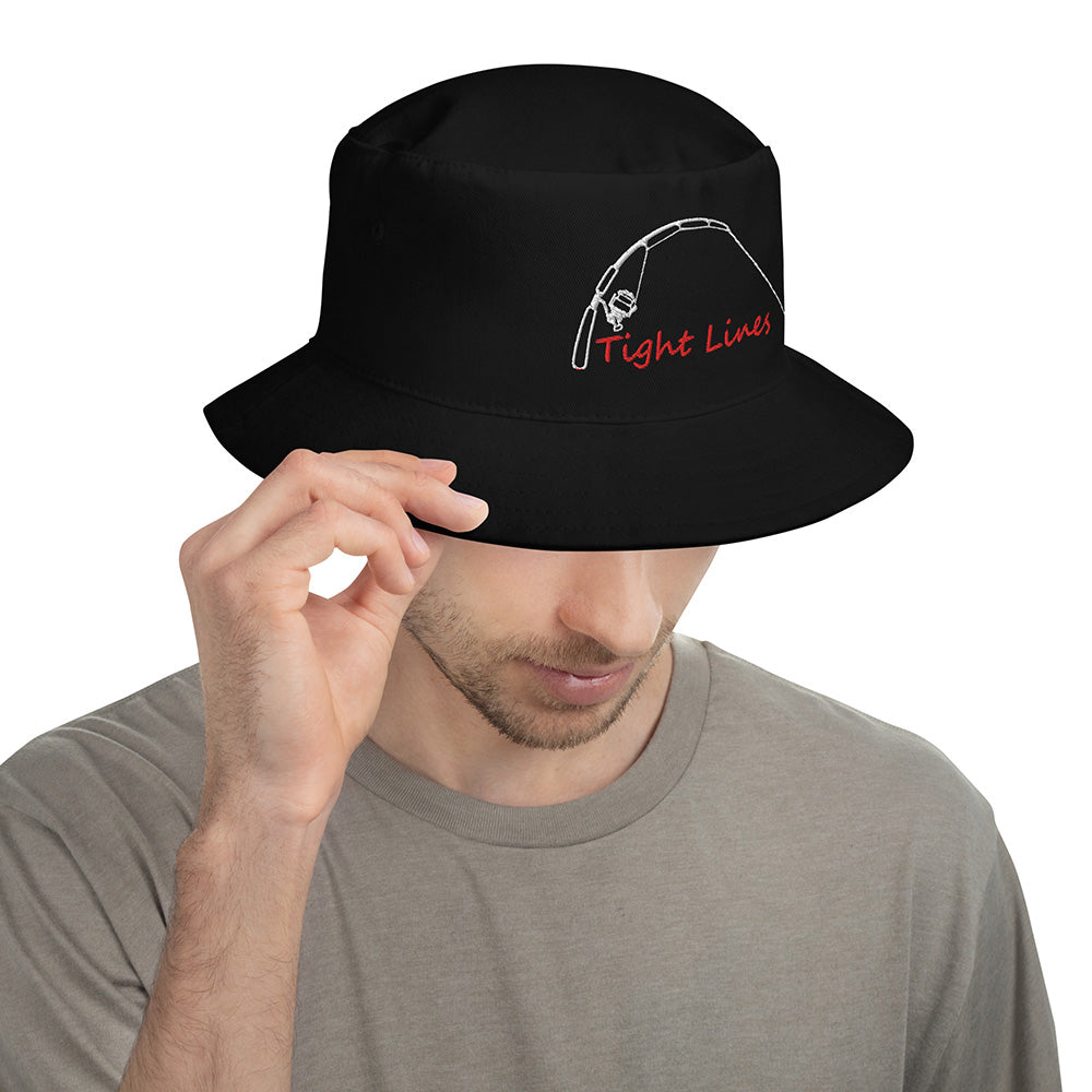 Black fishing bucket hat with embroidered 'Tight Lines' rod and reel design, shown on male model adjusting brim