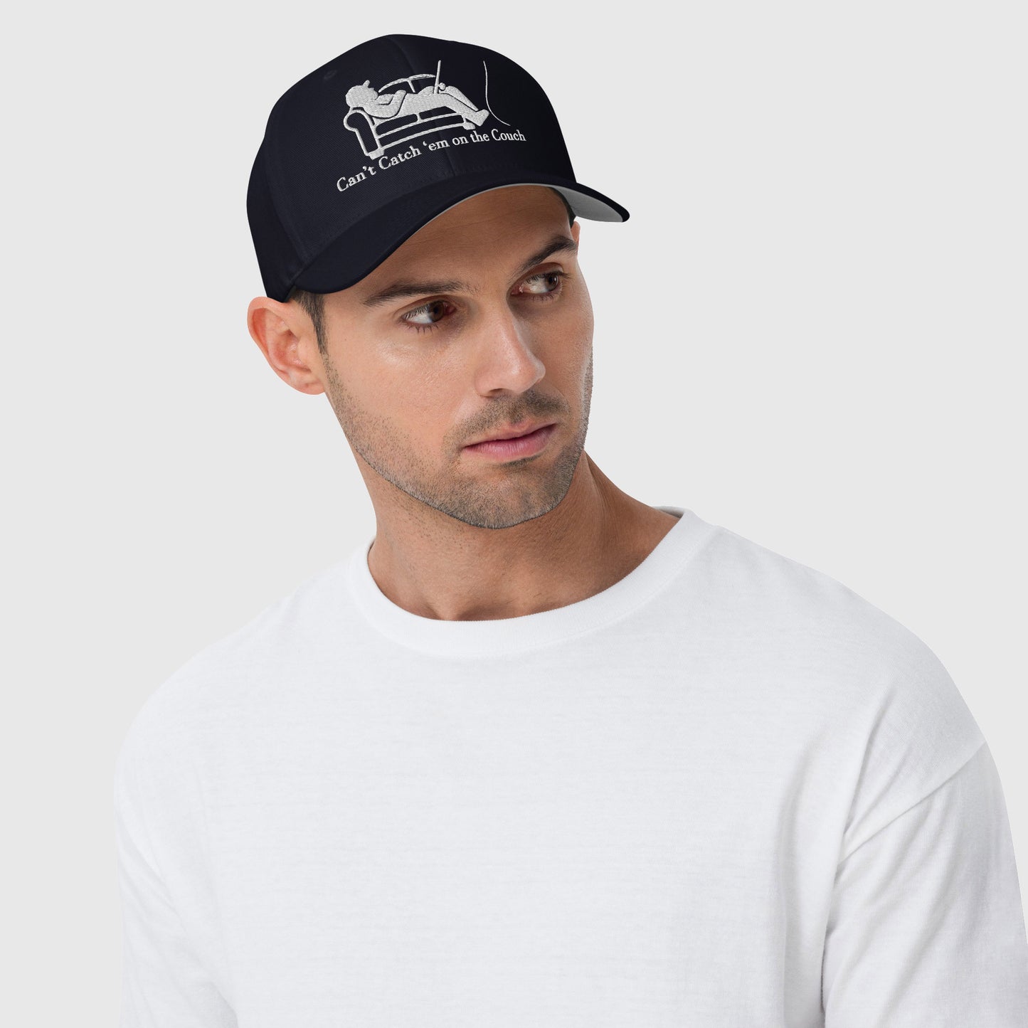 Man in white shirt modeling navy dad hat with couch fisherman graphic