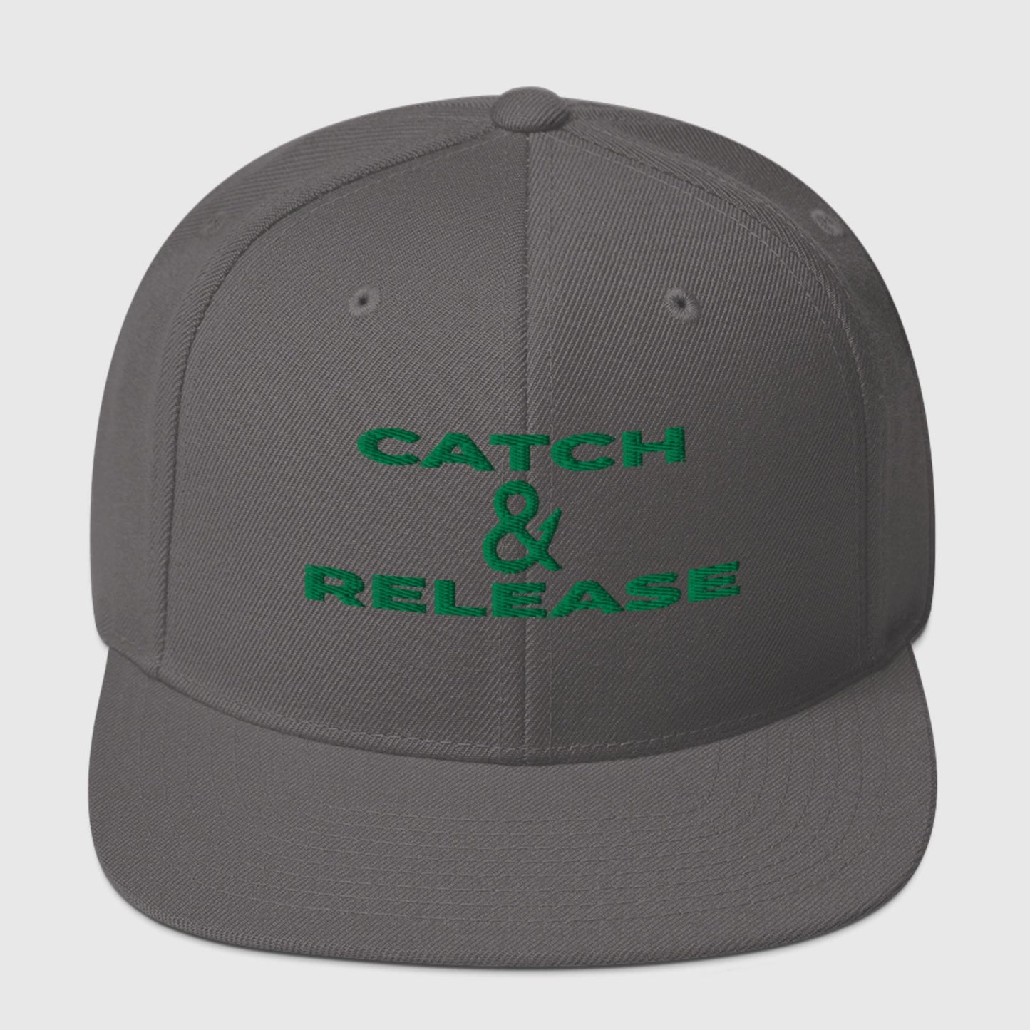 Dark grey snapback with green "Catch & Release" text, front view