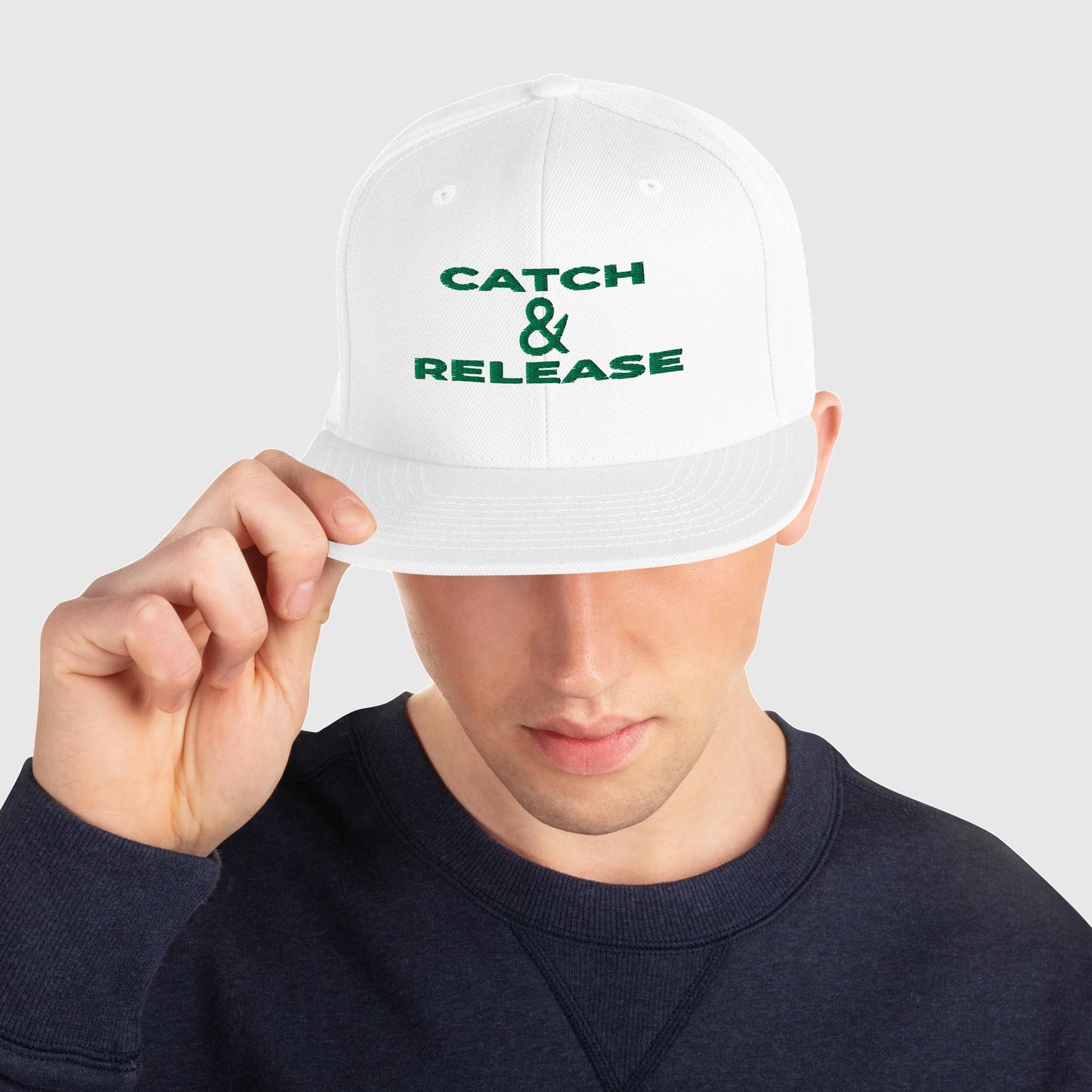 Man wearing white snapback with "Catch & Release" text, front view
