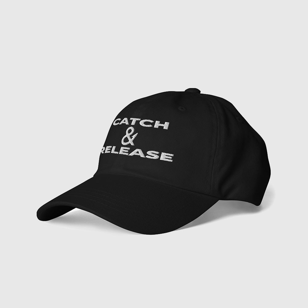 Side angle view of black dad hat with Catch & Release embroidery