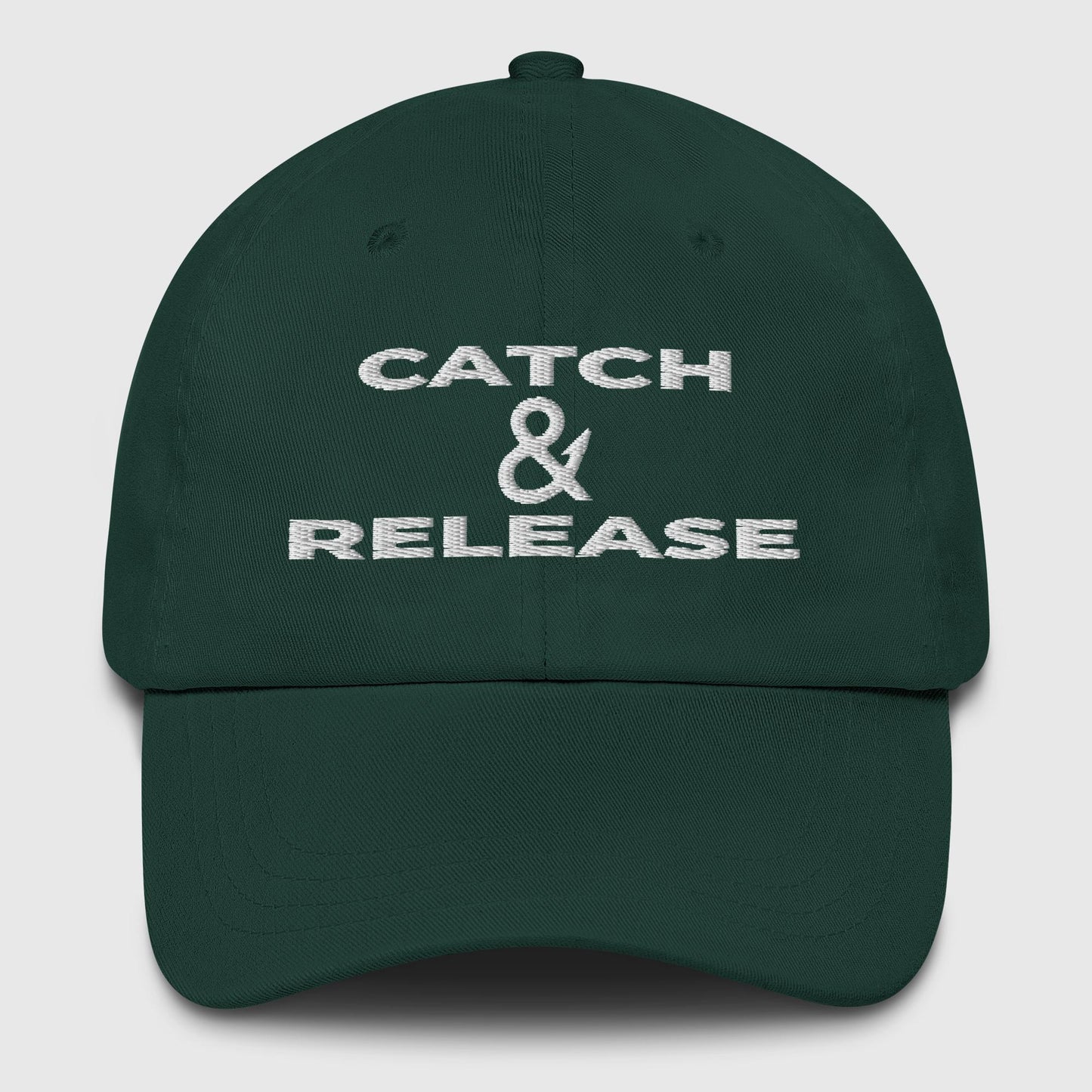Dark green dad hat with white embroidered Catch & Release slogan