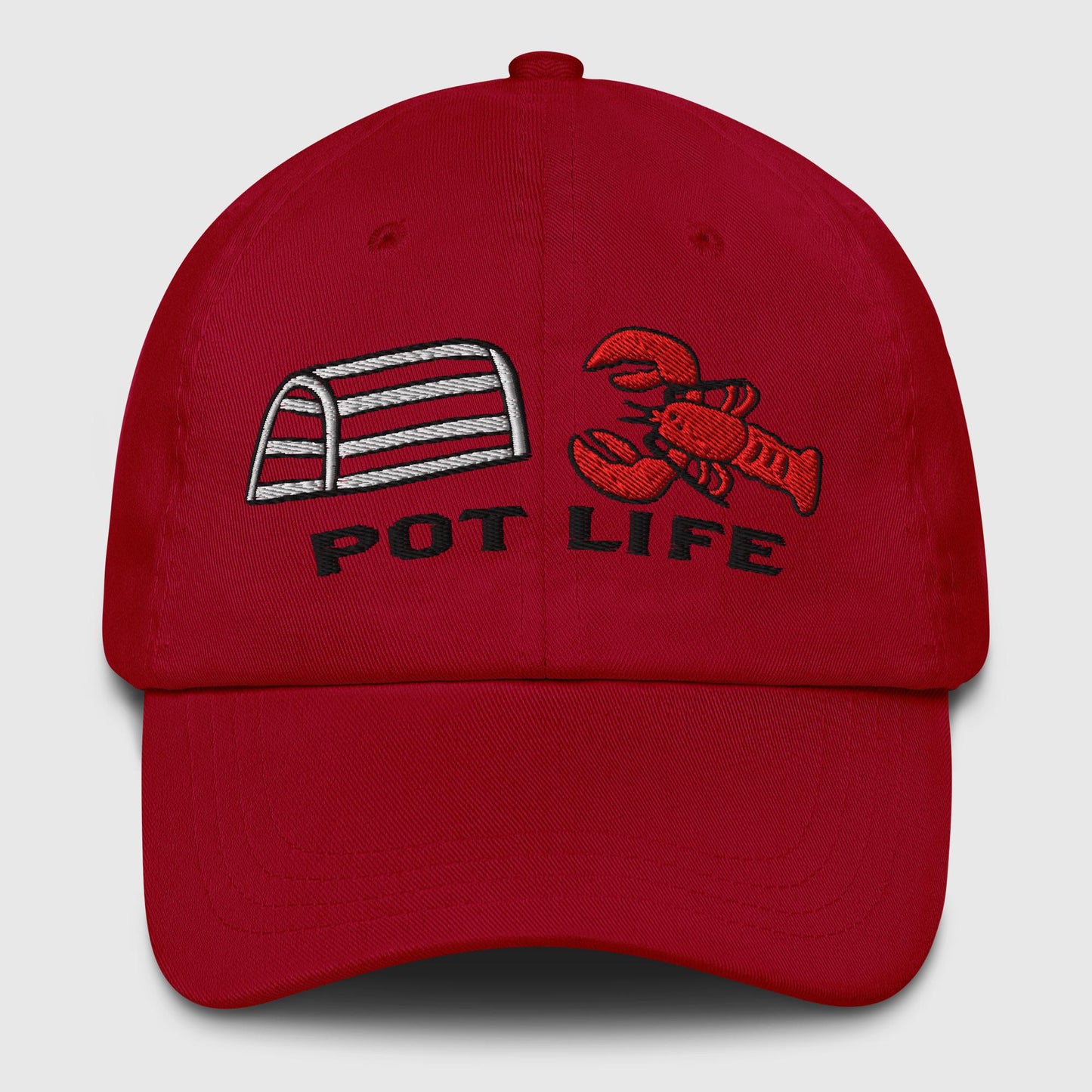 Cranberry red dad hat with embroidered lobster trap, red lobster, and "POT LIFE" text on the front