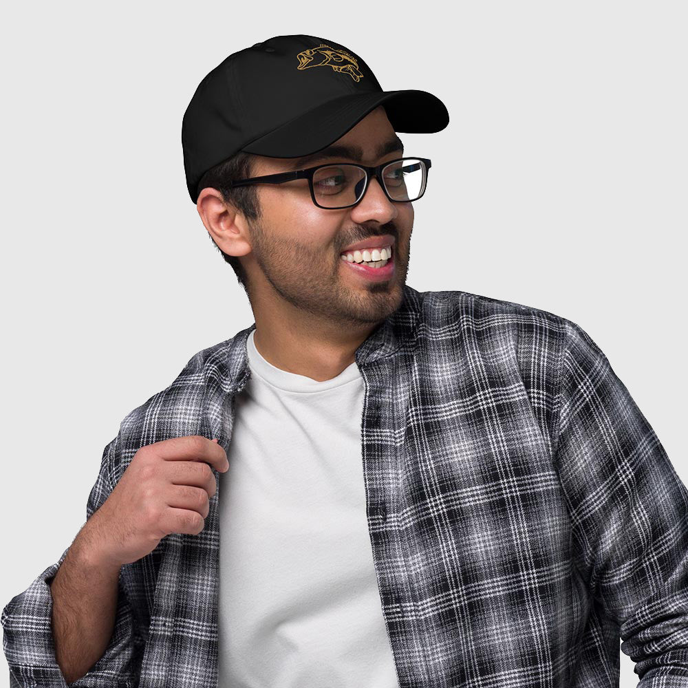Man wearing black dad hat with embroidered largemouth bass design in gold thread, casual outfit