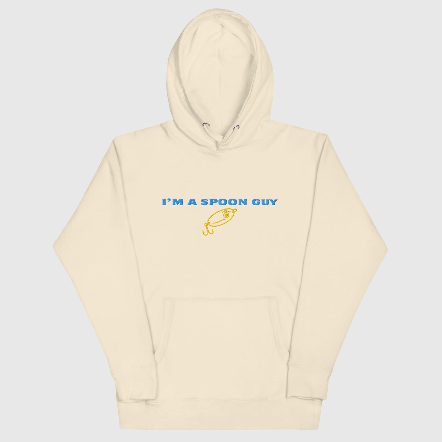 Sand-colored hoodie with "I’m a Spoon Guy" text and yellow spoon graphic on a plain background