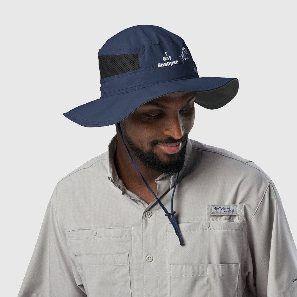 Man wearing navy Columbia bucket hat with embroidered “I Eat Snapper” text and fish design