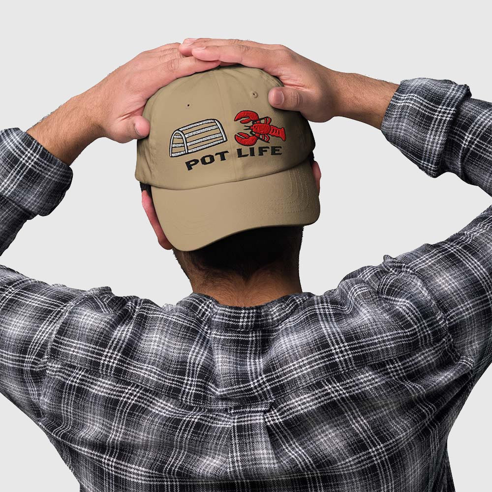 Man wearing khaki dad hat backwards showing lobster trap, red lobster, and "POT LIFE" embroidery