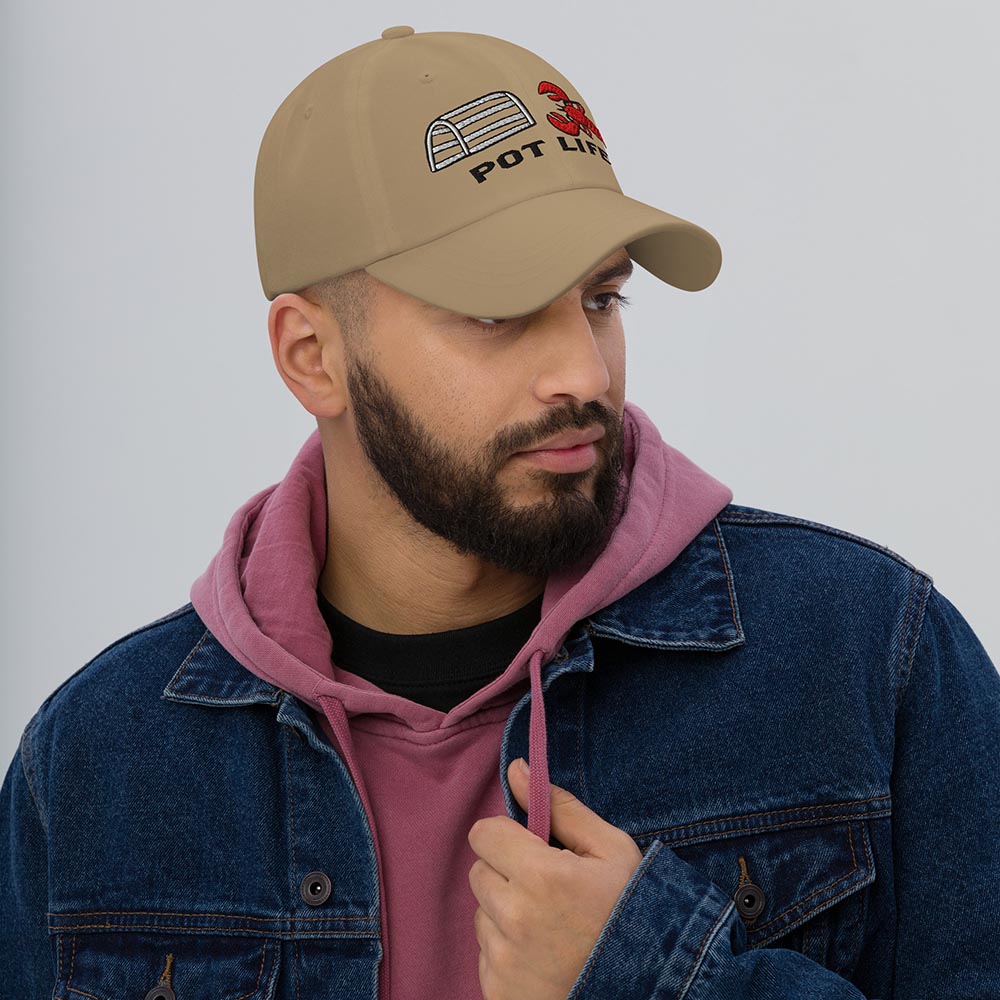 Man wearing khaki dad hat with lobster trap, red lobster, and "POT LIFE" embroidery