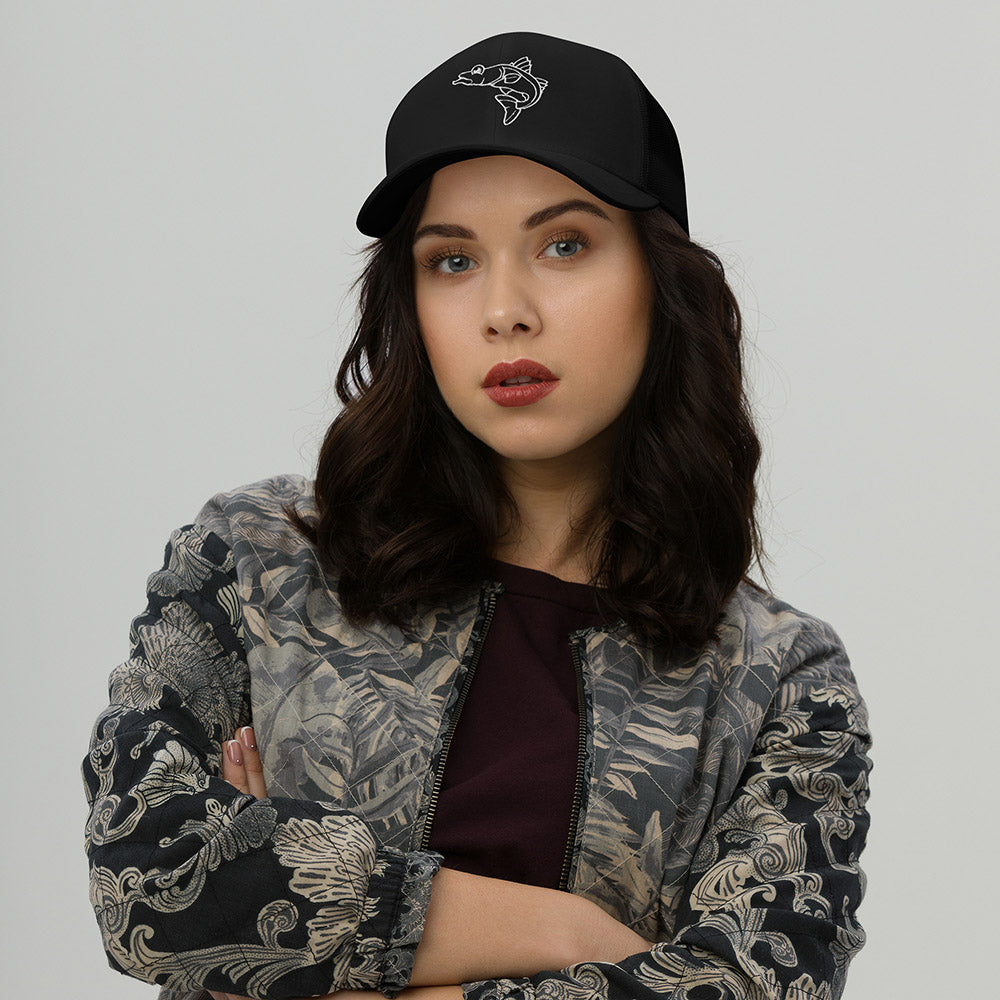 Woman wearing black retro trucker cap with white embroidered snook fish design