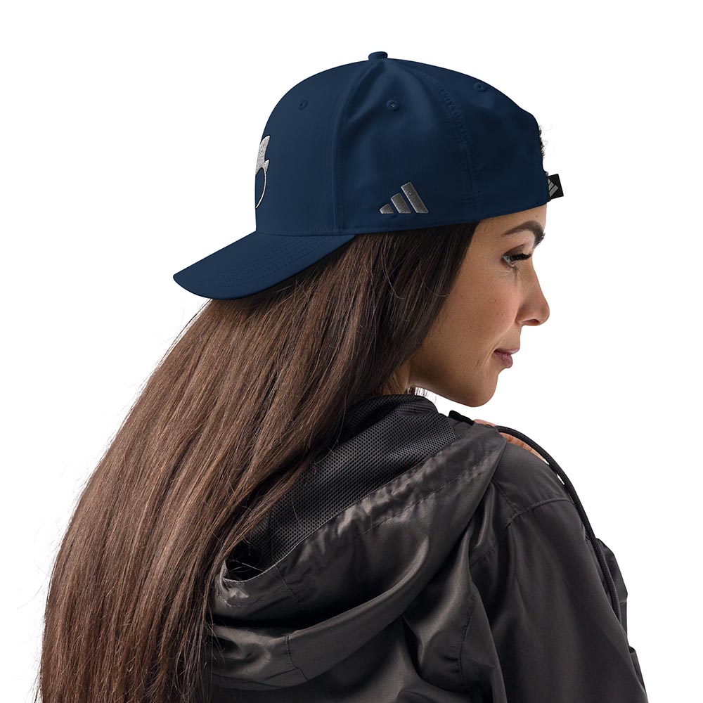 Woman wearing a navy Adidas performance cap with stingray logo, right-side profile