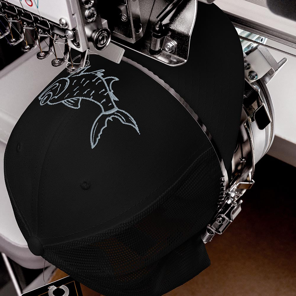 Black trucker hat with embroidered tarpon design on an embroidery machine during production