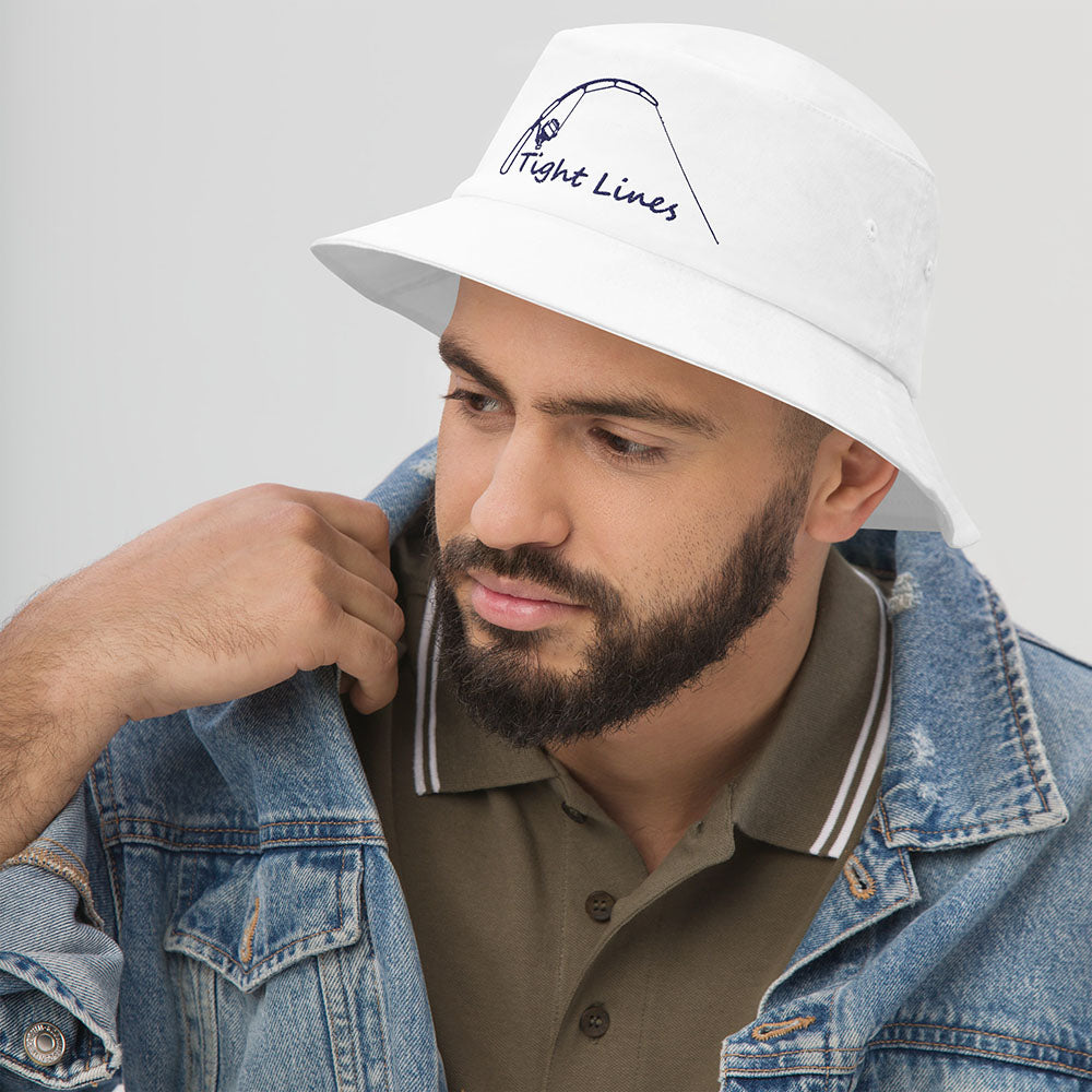 White bucket hat with embroidered 'Tight Lines' fishing rod and reel design, shown on model