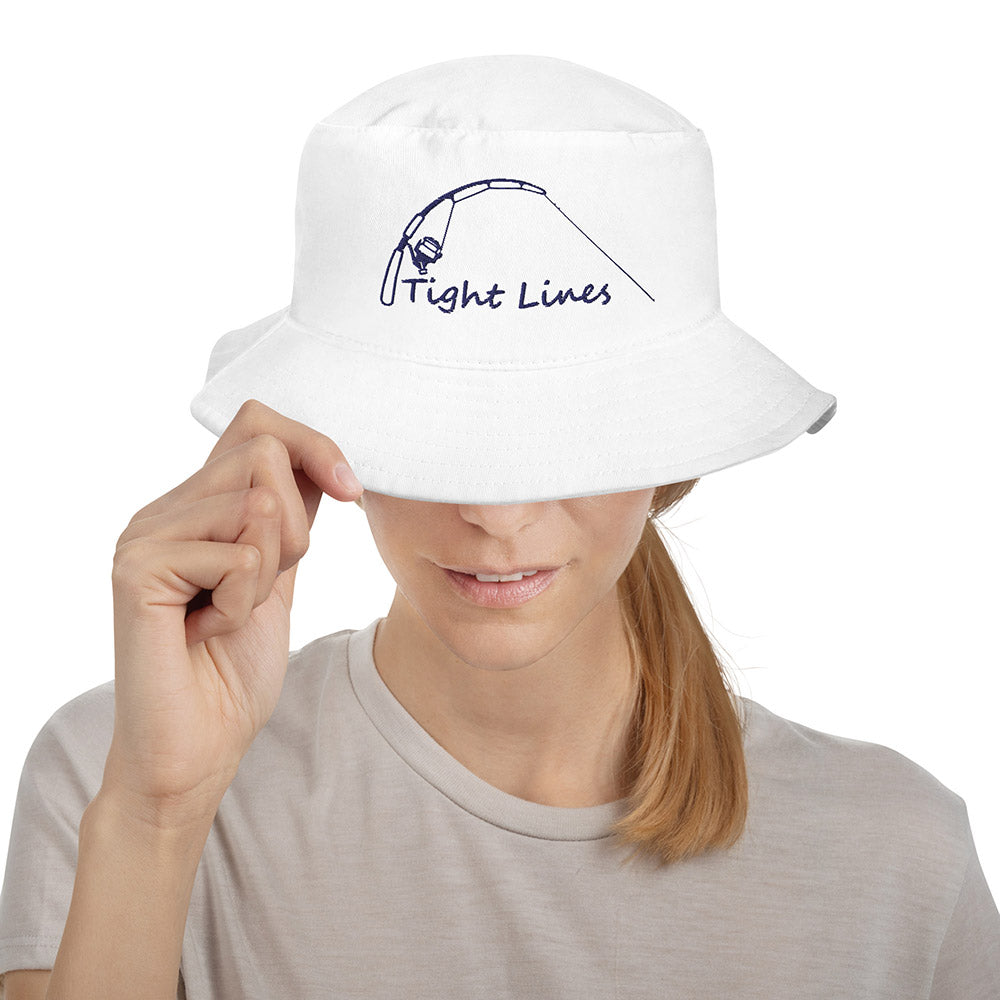 White bucket hat with embroidered 'Tight Lines' fishing rod and reel design, model adjusting brim
