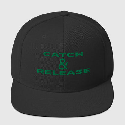 Black snapback fishing hat with green embroidered "Catch & Release" text, funny fishing hat design. - Catch & Release Snapback