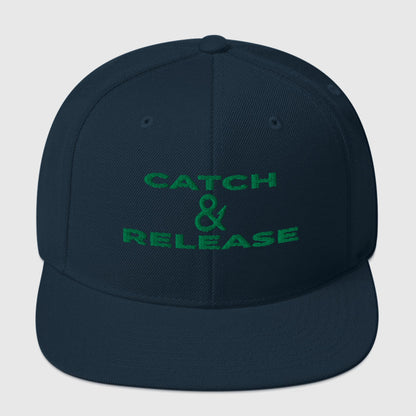 Dark navy snapback fishing hat with green "Catch & Release" text, funny fishing hat style. - Catch & Release Snapback