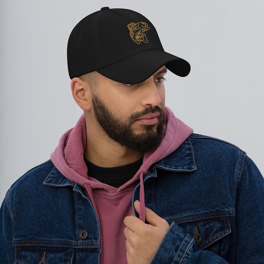 Man wearing a black dad hat with gold bass emblem